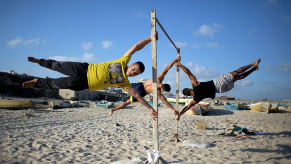 Members of Bar Palestine, a street workout team practice their skills during a training session on the beach of Gaza City Members of Bar Palestine, a street workout team practice their skills during a training session on the beach of Gaza City - Sputnik International