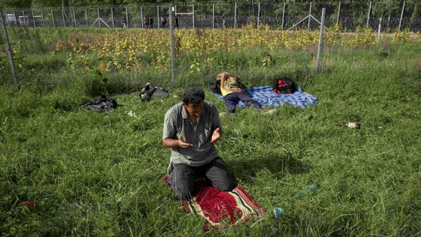 A migrant prays near the border fence with Hungary in Horgos, Serbia, September 15, 2015. A migrant prays near the border fence with Hungary in Horgos, Serbia, September 15, 2015. - Sputnik International