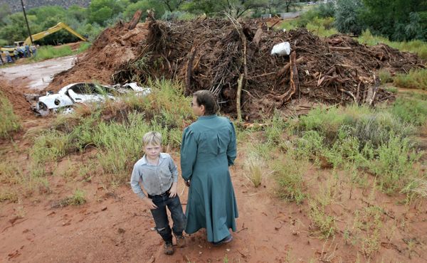 People look over debris and the remains of a car following a flash flood Tuesday. - Sputnik International