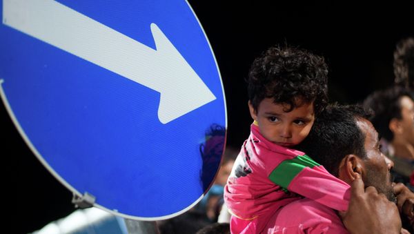 Refugees queue up for a bus, as they arrive at the border between Austria and Hungary, Heiligenkreuz, Austria, late Tuesday Sept. 15, 2015. - Sputnik International