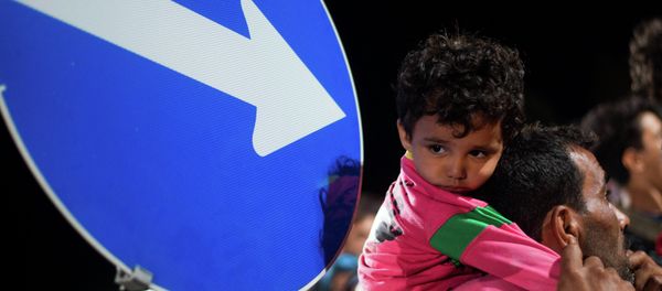 Refugees queue up for a bus, as they arrive at the border between Austria and Hungary, Heiligenkreuz, Austria, late Tuesday Sept. 15, 2015. - Sputnik International