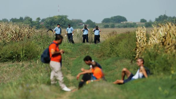 Croatian policemen observe a group of migrants on the border with Serbia near Tovarnik, Croatia September 16, 2015 Croatian policemen observe a group of migrants on the border with Serbia near Tovarnik, Croatia September 16, 2015 - Sputnik International