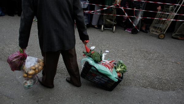 A man pulls a crate of vegetables he has got for free from protesting farmers' market vendors. A man pulls a crate of vegetables he has got for free from protesting farmers' market vendors. - Sputnik International