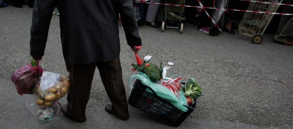A man pulls a crate of vegetables he has got for free from protesting farmers' market vendors. A man pulls a crate of vegetables he has got for free from protesting farmers' market vendors. - Sputnik International