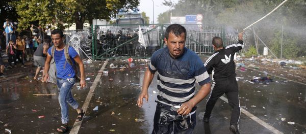 Migrants run as Hungarian riot police fires tear gas and water cannon at the border crossing with Serbia in Roszke, Hungary September 16, 2015 Migrants run as Hungarian riot police fires tear gas and water cannon at the border crossing with Serbia in Roszke, Hungary September 16, 2015 - Sputnik International