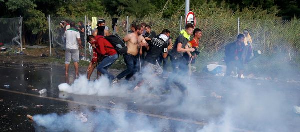 Migrants protest as Hungarian riot police fires tear gas and water cannon at the border crossing with Serbia in Roszke, Hungary September 16, 2015 Migrants protest as Hungarian riot police fires tear gas and water cannon at the border crossing with Serbia in Roszke, Hungary September 16, 2015 - Sputnik International