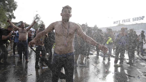 Migrants protest as Hungarian riot police fires tear gas and water cannon on the Serbian side of the border, near Roszke, Hungary September 16, 2015 - Sputnik International