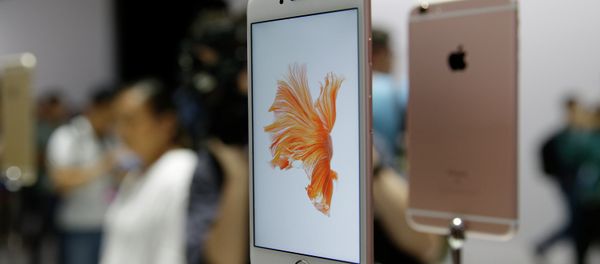 People look over the new Apple iPhone 6s models during a product display. - Sputnik International