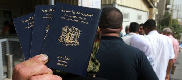 Syrian man holds his family's passports - Sputnik International