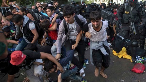 Migrants run as Hungarian riot police fires tear gas and water cannon at the border crossing with Serbia in Roszke, Hungary September 16, 2015. - Sputnik International