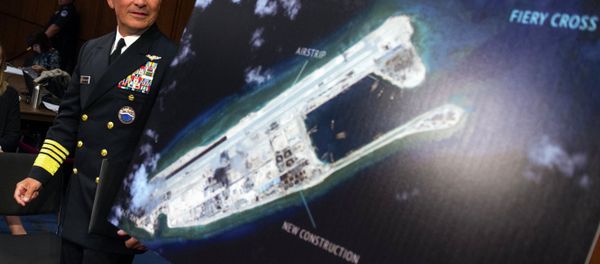 Adm. Harry B. Harris, Jr., US Navy Commander, U.S. Pacific Command walks past a photograph showing an island that China is building on the Fiery Cross Reef in the South China Sea - Sputnik International