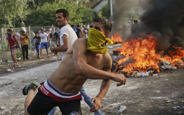 Migrants protest as Hungarian riot police fires tear gas and water cannon at the border crossing with Serbia in Roszke, Hungary - Sputnik International