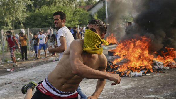 Migrants protest as Hungarian riot police fires tear gas and water cannon at the border crossing with Serbia in Roszke, Hungary - Sputnik International