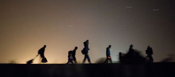 Migrants walk towards a checkpoint along the railway tracks connecting Horgos and Szeged near Roszke, in the vicinity of the border between Hungary and Serbia - Sputnik International