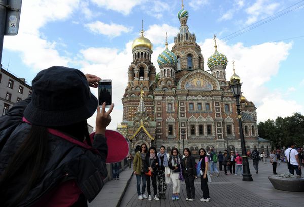 A picture taken on September 4, 2015 shows Chinese tourists as they have their photo taken in front of Church of the Savior on Blood in central St. Petersburg. Drawn by its Communist past and a visa-free regime, Chinese tourists are flocking to Russia in droves as it develops new routes touting red tourism A picture taken on September 4, 2015 shows Chinese tourists as they have their photo taken in front of Church of the Savior on Blood in central St. Petersburg. Drawn by its Communist past and a visa-free regime, Chinese tourists are flocking to Russia in droves as it develops new routes touting red tourism - Sputnik International