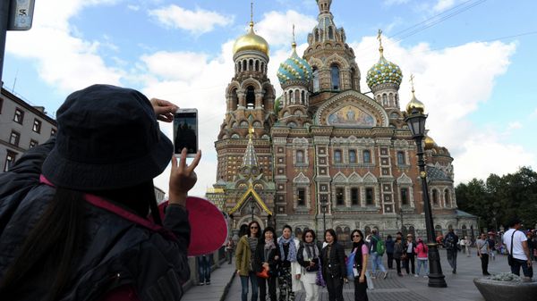 A picture taken on September 4, 2015 shows Chinese tourists as they have their photo taken in front of Church of the Savior on Blood in central St. Petersburg. Drawn by its Communist past and a visa-free regime, Chinese tourists are flocking to Russia in droves as it develops new routes touting red tourism A picture taken on September 4, 2015 shows Chinese tourists as they have their photo taken in front of Church of the Savior on Blood in central St. Petersburg. Drawn by its Communist past and a visa-free regime, Chinese tourists are flocking to Russia in droves as it develops new routes touting red tourism - Sputnik International