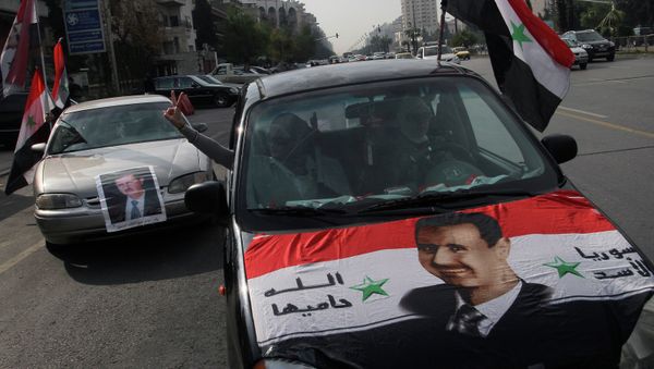Syrians display national flags and banners with photos of Syrian President Bashar Assad. Syrians display national flags and banners with photos of Syrian President Bashar Assad. - Sputnik International