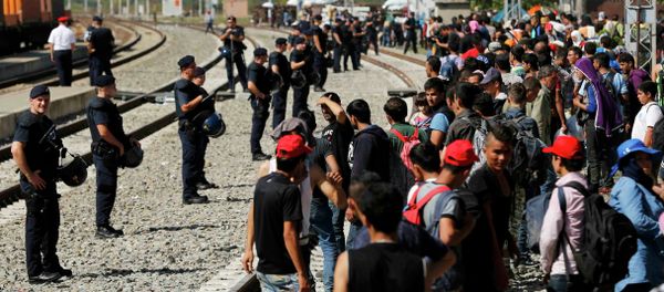Police form a line in front of migrants at the railway station in Tovarnik, Croatia September 18, 2015 Police form a line in front of migrants at the railway station in Tovarnik, Croatia September 18, 2015 - Sputnik International