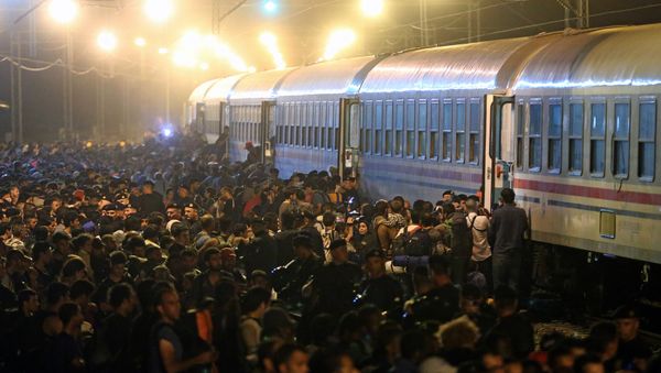 Migrants rush to board a train in the eastern-Croatia town of Tovarnik, close to the border between Croatia and Serbia on September 18, 2015 - Sputnik International
