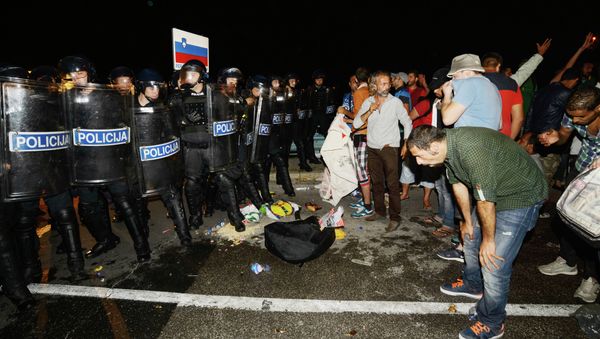 Migrants react after pepper spray was used in a small village of Rigonce in Slovenia, a small border crossing point to Harmica, Croatia, on September 18, 2015 - Sputnik International
