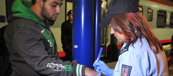 A Czech police officer writes a number on the skin of a refugee in Breclav, Czech Republic September 1, 2015. Picture taken September 1, 2015 A Czech police officer writes a number on the skin of a refugee in Breclav, Czech Republic September 1, 2015. Picture taken September 1, 2015 - Sputnik International