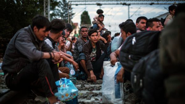 Migrants wait to be allowed by Croatian police to board a train at the station in Tovarnik, Croatia, Saturday, Sept. 19, 2015 - Sputnik International