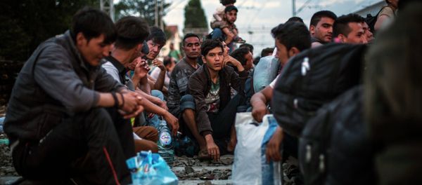 Migrants wait to be allowed by Croatian police to board a train at the station in Tovarnik, Croatia, Saturday, Sept. 19, 2015 - Sputnik International