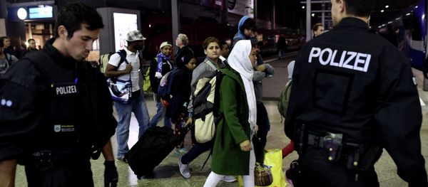 Syrian refugees and migrants are escorted to be registred by German police officers upon arrival from Austria at the Munich's main train station late September 3, 2015. - Sputnik International