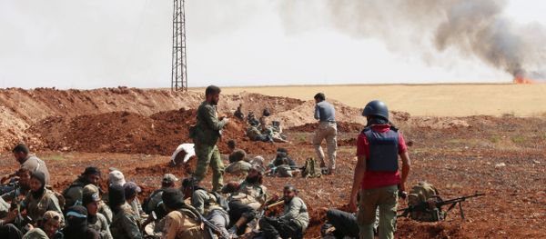 An unidentified photographer stands next to rebel fighters from Jaysh al-Islam (Army of Islam) holding a position behind a sand barrier on August 25, 2015, on the frontline in the Bashkoy area, on the northern outskirts of Aleppo, where opposition fighters are battling Syrian pro-government forces An unidentified photographer stands next to rebel fighters from Jaysh al-Islam (Army of Islam) holding a position behind a sand barrier on August 25, 2015, on the frontline in the Bashkoy area, on the northern outskirts of Aleppo, where opposition fighters are battling Syrian pro-government forces - Sputnik International
