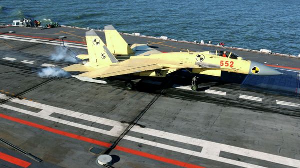 In this undated photo released by China's Xinhua News Agency, a carrier-borne J-15 fighter jet lands on China's first aircraft carrier, the Liaoning - Sputnik International