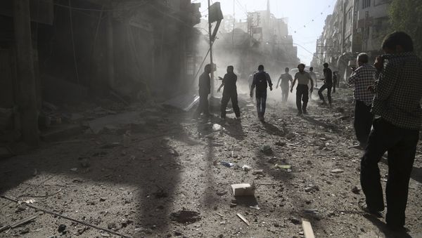 Residents inspect damage after what activists said was an airstrike by forces loyal to Syria's President Bashar al-Assad on the town of Douma, eastern Ghouta of Damascus September 19, 2015 - Sputnik International