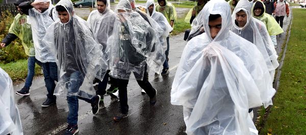 Refugees walked in heavy rain from a public transport centre to Lappia-building refugee reception centre in Tornio, northwestern Finland, September 18, 2015 Refugees walked in heavy rain from a public transport centre to Lappia-building refugee reception centre in Tornio, northwestern Finland, September 18, 2015 - Sputnik International