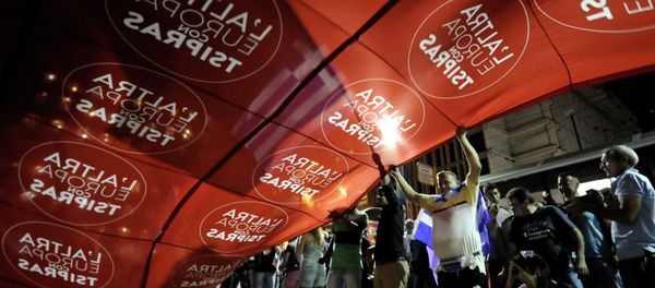 Supporters of Syriza wave a giant flag reads in Italian The other Europe with Tsipras'' at party’s main electoral center in Athens, Sunday, Sept. 20, 2015 - Sputnik International