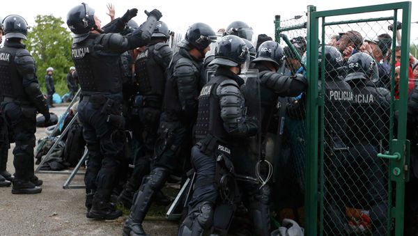 Police try to stop migrants pushing to enter a bus at the Croatia-Slovenia border crossing at Bregana, Croatia, September 20, 2015 Police try to stop migrants pushing to enter a bus at the Croatia-Slovenia border crossing at Bregana, Croatia, September 20, 2015 - Sputnik International