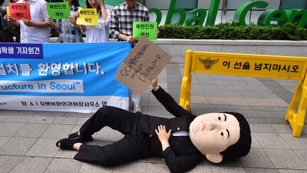 A South Korean activist wearing a mask depicting North Korean leader Kim Jong-Un lies on a street during a rally to welcome the opening of the UN Human Rights office at Seoul Global Center in Seoul on June 23, 2015 A South Korean activist wearing a mask depicting North Korean leader Kim Jong-Un lies on a street during a rally to welcome the opening of the UN Human Rights office at Seoul Global Center in Seoul on June 23, 2015 - Sputnik International