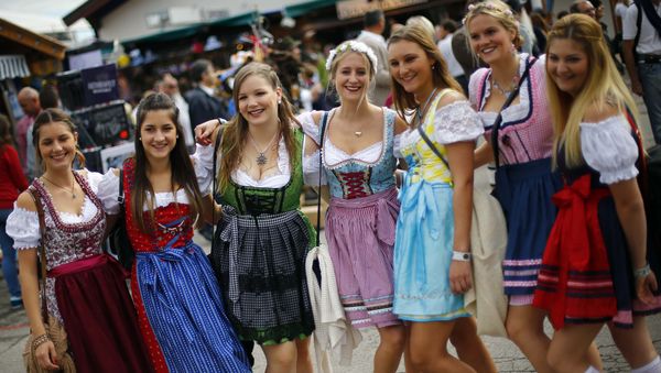 Young womae pose for a photo during the opening of the 182. Oktoberfest beer festival in Munich, southern Germany, Saturday, Sept. 19, 2015 - Sputnik International