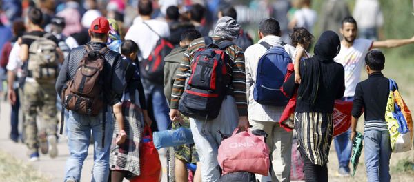 Migrants carry their belongings as they walk towards the Austrian border from Hegyeshalom, Hungary September 23, 2015. - Sputnik International