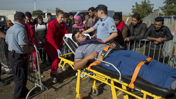 A migrant is carried on a stretcher after he collapsed in front of a registration camp in Opatovac, Croatia September 23, 2015. A migrant is carried on a stretcher after he collapsed in front of a registration camp in Opatovac, Croatia September 23, 2015. - Sputnik International