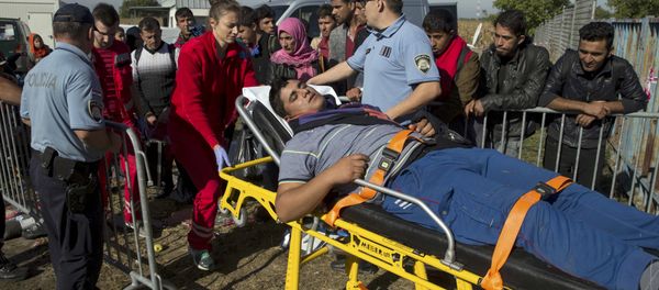 A migrant is carried on a stretcher after he collapsed in front of a registration camp in Opatovac, Croatia September 23, 2015. A migrant is carried on a stretcher after he collapsed in front of a registration camp in Opatovac, Croatia September 23, 2015. - Sputnik International