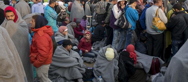 Migrants wait to board buses on a field, after they crossed the border with Serbia, near the village of Babska, Croatia September 24, 2015 - Sputnik International