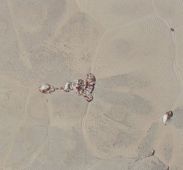 Zooming in on the right section of the above photo shows the textured surface of the plain surrounding two isolated ice mountains. Zooming in on the right section of the above photo shows the textured surface of the plain surrounding two isolated ice mountains. - Sputnik International