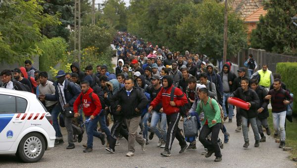 Migrants run as they follow a police vehicle on their way to the Austrian border in Nickelsdorf from Hegyeshalom, Hungary September 25, 2015. - Sputnik International