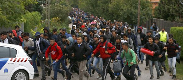 Migrants run as they follow a police vehicle on their way to the Austrian border in Nickelsdorf from Hegyeshalom, Hungary September 25, 2015. Migrants run as they follow a police vehicle on their way to the Austrian border in Nickelsdorf from Hegyeshalom, Hungary September 25, 2015. - Sputnik International
