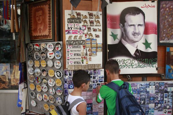 Syrian students, look for souvenir items at a shop displaying a portrait of Syrian President Bashar Assad with Arabic legend reads We love you, in the old city of Damascus, Syria - Sputnik International