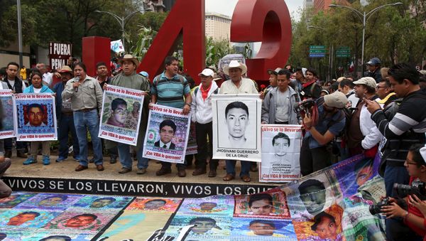 Relatives hold pictures of some of the 43 missing students of Ayotzinapa College Raul Isidro Burgos during a march to mark the first anniversary of their disappearance, in Mexico City, September 26, 2015 Relatives hold pictures of some of the 43 missing students of Ayotzinapa College Raul Isidro Burgos during a march to mark the first anniversary of their disappearance, in Mexico City, September 26, 2015 - Sputnik International