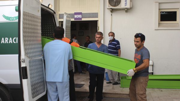 People upload coffins with the bodies of migrants that were drowned while they were trying to cross on a boat to the nearby Greek island of Kos, to the hospital's morgue at the coastal town of Bodrum, Turkey, Sunday, Sept. 27, 2015. Turkey's coast guard says that 17 migrants have drowned after a vessel carrying them toward Greece sank in the Aegean Sea - Sputnik International