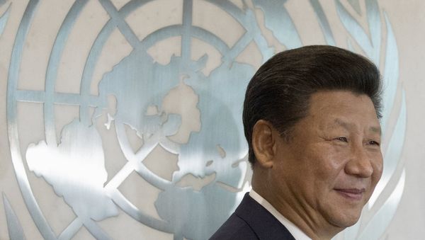 Chinese President Xi Jinping stands in front of the United Nations emblem as he poses for a photograph with U.N. Secretary-General Ban Ki-moon (unseen) after addressing the United Nations Sustainable Development Summit 2015 at the United Nations headquarters in Manhattan, New York September 26, 2015 - Sputnik International
