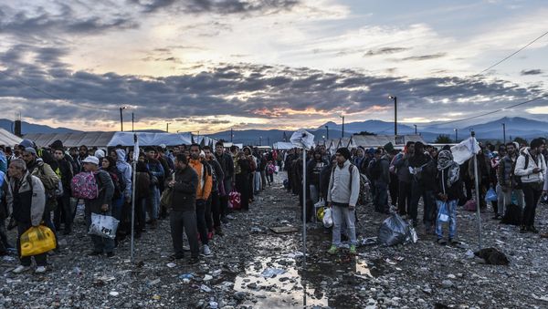 Migrants and refugees wait to board a train near Gevgelija in southern Macedonia after crossing the Greek-Macedonian border on September 27, 2015 - Sputnik International