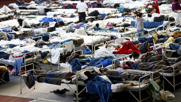 Migrants sit on their beds at an improvised temporary shelter in a sports hall in Hanau, Germany, September 24, 2015 Migrants sit on their beds at an improvised temporary shelter in a sports hall in Hanau, Germany, September 24, 2015 - Sputnik International