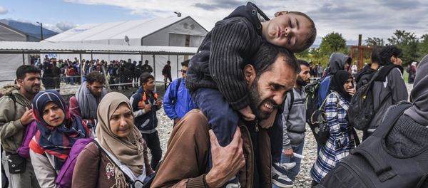Migrants and refugees stand in line as they wait to board a train at the registration camp after crossing the Macedonian-Greek border near Gevgelija on September 28, 2015 Migrants and refugees stand in line as they wait to board a train at the registration camp after crossing the Macedonian-Greek border near Gevgelija on September 28, 2015 - Sputnik International